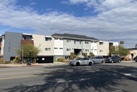A modern building with a parking lot in front.