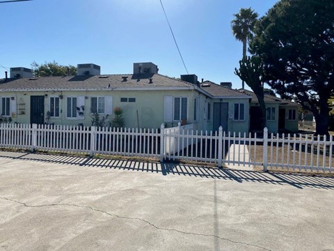 A house with a white picket fence in front.