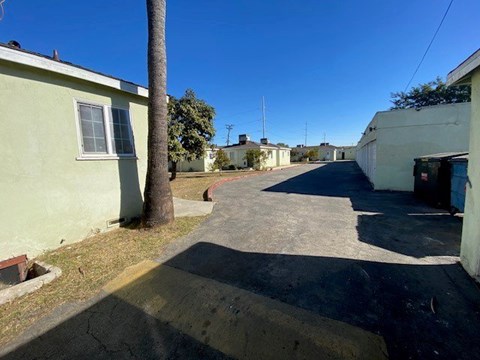 A residential street with houses on both sides and a clear blue sky.
