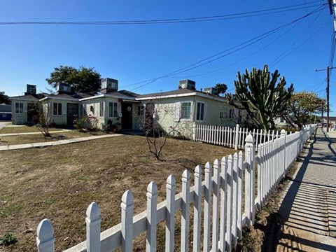 A white picket fence in front of a house.