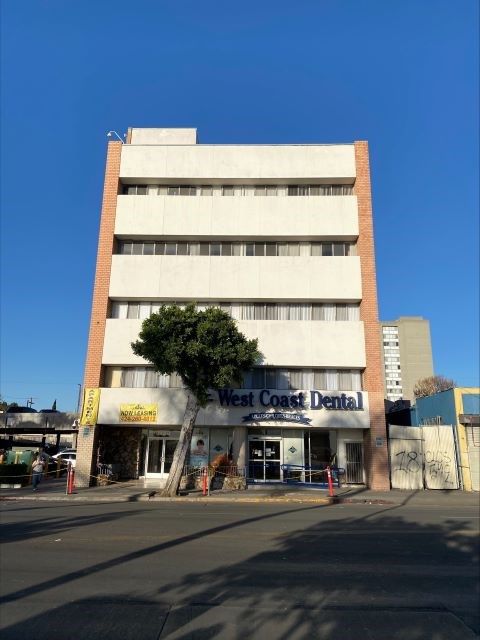 A West Coast Dental building with a tree in front.