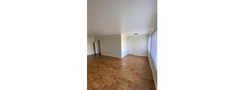 A room with wooden flooring and white walls.