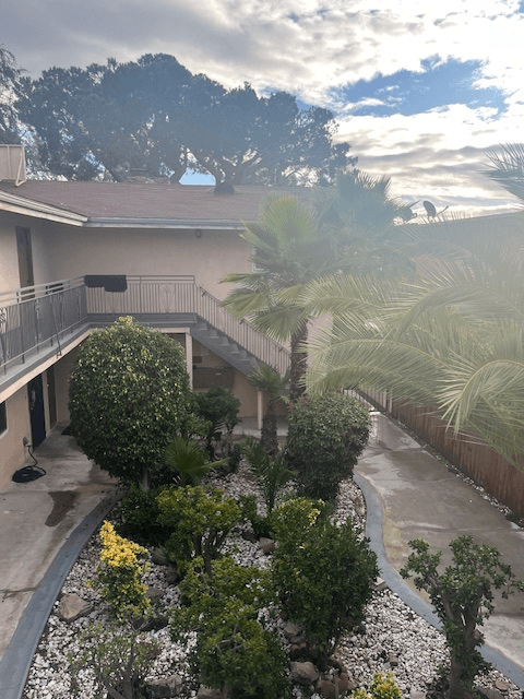 A house with a balcony and a garden in front.
