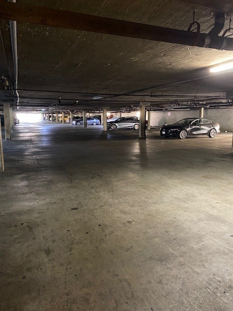 A parking garage with a few cars parked in it.