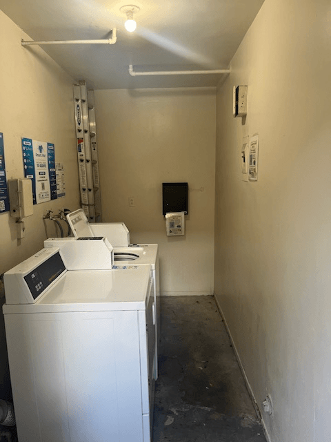 A white washing machine is in a small room.
