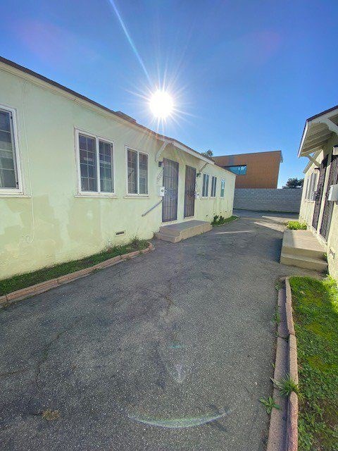 A sunny day at a residential area with a building and a paved area.