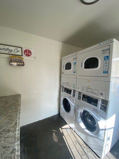 A wall with a sign that says "dryry Co" and a stack of washers and dryers.