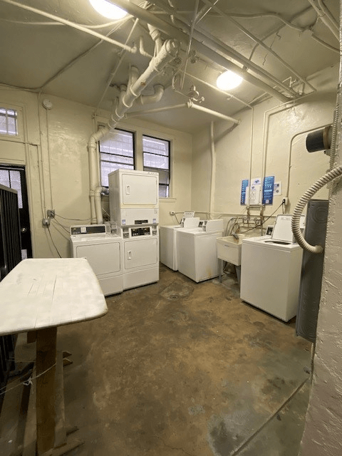 A room with white appliances and a concrete floor.