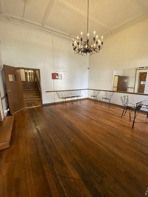 A large room with wooden floors and a chandelier.