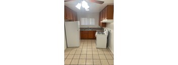 A kitchen with white appliances and brown cabinets.