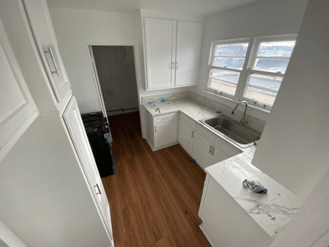 A kitchen with white cabinets and a white fridge.