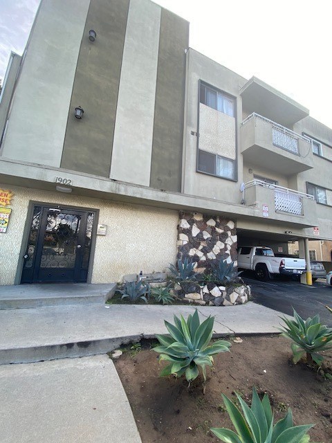 A concrete building with a black door and windows.
