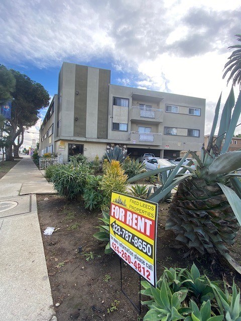 A building with a sign in front of it that says "FOR RENT".