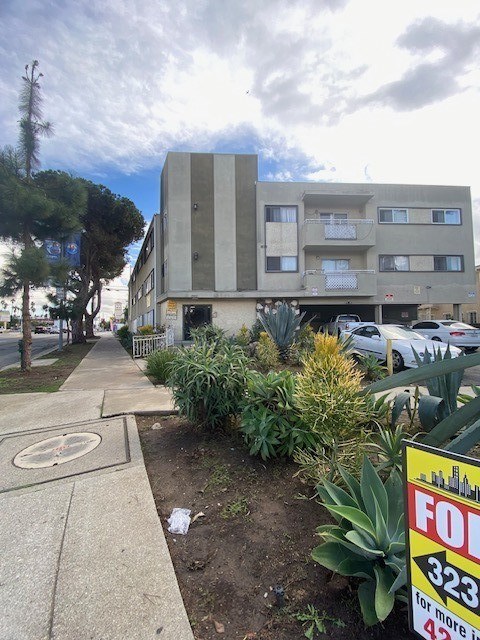 A building with a sign that says "FOR 323" in front of it.