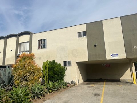 A concrete building with a parking garage in front.