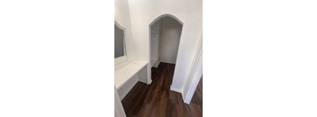 A hallway with a bench and arched doorways.