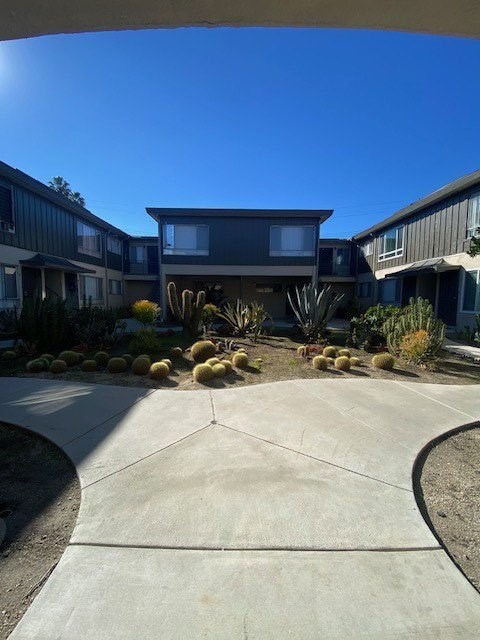 A modern house with a grey exterior and a concrete driveway.