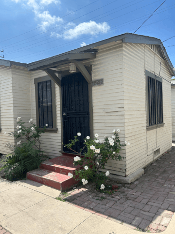 A small white house with a black door and windows.