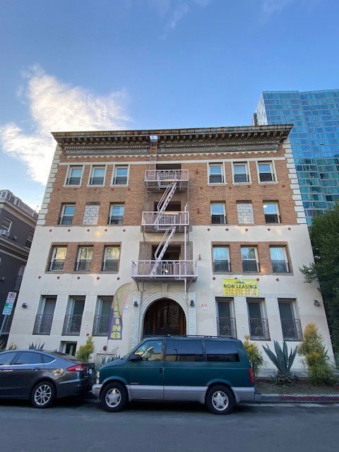 A building with a sign that says "NO LEASING" is in front of a blue building.