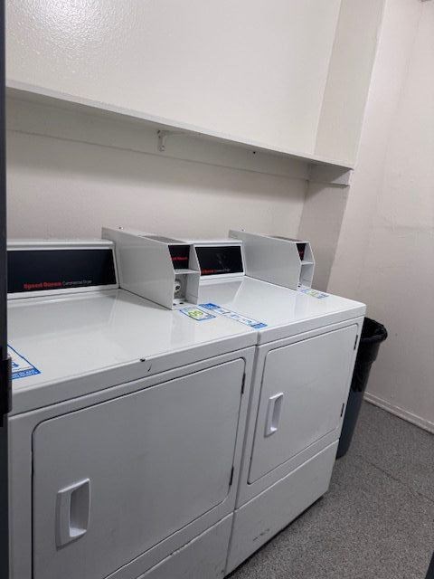A white cabinet with a black bin underneath it.