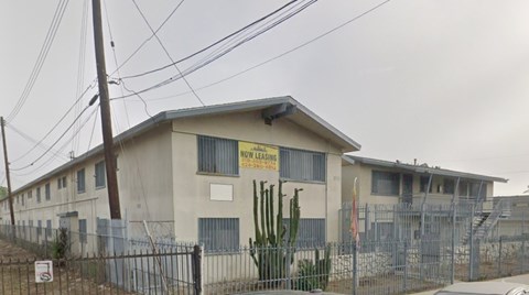 A building with a sign that says "Now Lease" in front of it.