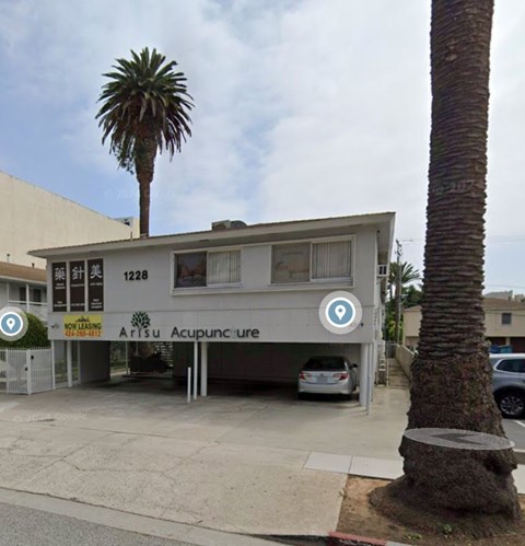 A building with a sign that says Arisu Acupuncture.