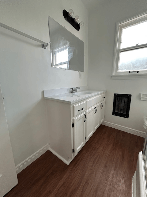 A bathroom with a sink and mirror.