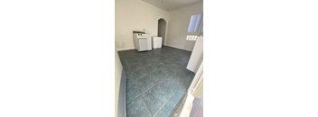 A kitchen area with a sink, dishwasher, and a window.