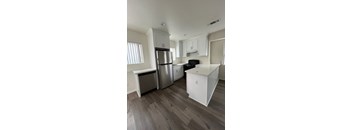 A kitchen with a stainless steel refrigerator, oven, and cabinets.
