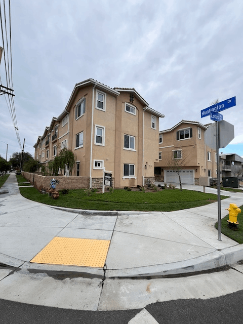 A street corner with a crosswalk and a building in the background.