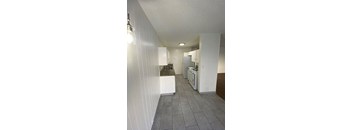 A kitchen with white cabinets and a white fridge.