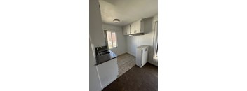 A kitchen with a sink and a refrigerator.