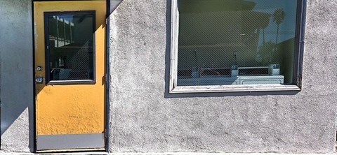 A yellow door is on the left and a window is on the right.
