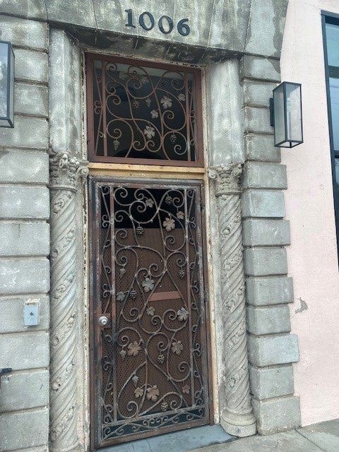 A wrought iron door with a glass window above it.