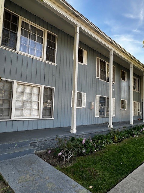 A grey house with white trim and a small garden in front.