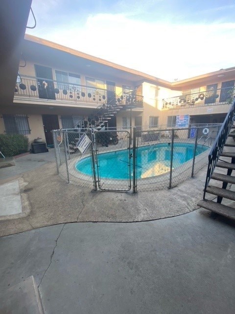 A pool surrounded by a fence in a courtyard.