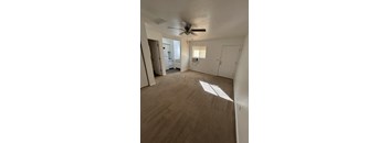 A room with a ceiling fan and a window letting in sunlight.