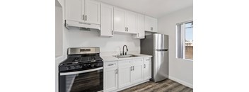 A kitchen with white cabinets and a black stove top oven.