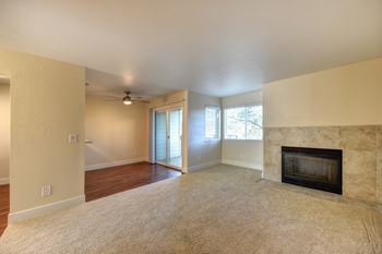 Vacant apartment home with wood brining fireplace in the living room.  Living room has lighter colored carpeting.at Folsom Ranch, California, 95630
