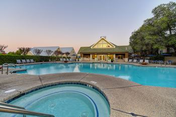 Pool and Spa at dusk.  Lights inside the pools and spa are illuminating the water.  View of the leasing office is in the distance.at Folsom Ranch, Folsom, CA