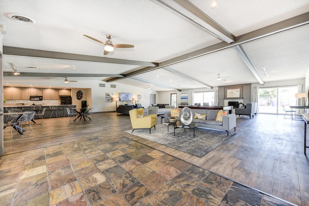 Clubhouse Sitting Area with Hardwood Inspired Floor, Gray Sofa, Rug and Ceiling Fan/Light at The Renaissance Apartments, Citrus Heights, CA 95610