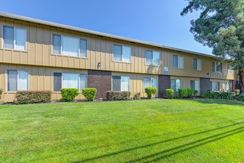 Asbury Place Apartment buildings with green grass outside and large trees