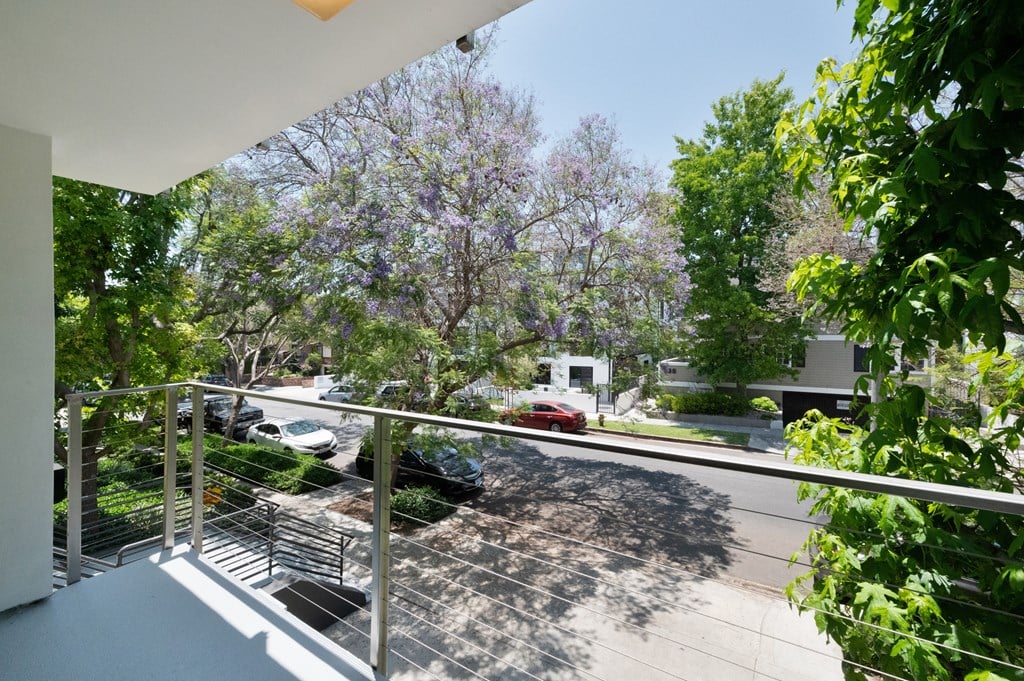 a balcony with a metal railing and a view of a street at Croft Plaza Apartments, California