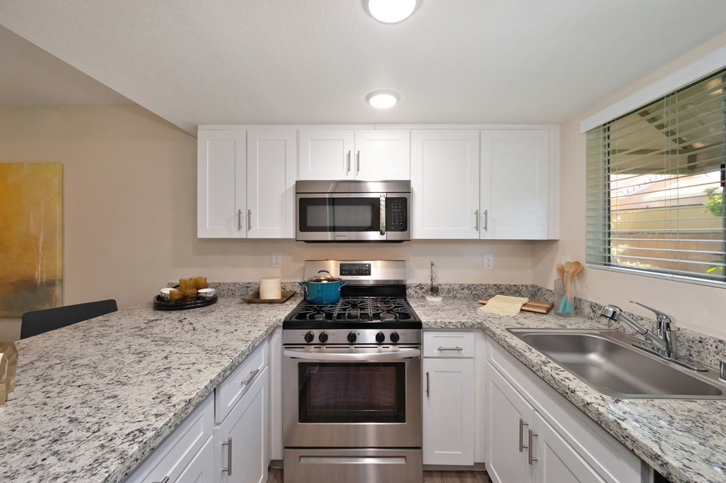 a kitchen with white cabinets and granite countertops