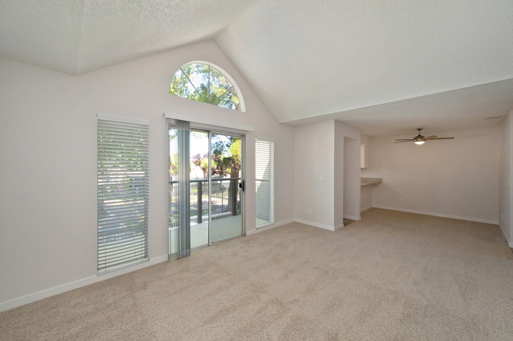 a living room with an arched window and a door leading to a balcony