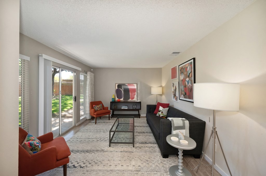 a living room with a couch and chairs and a tv