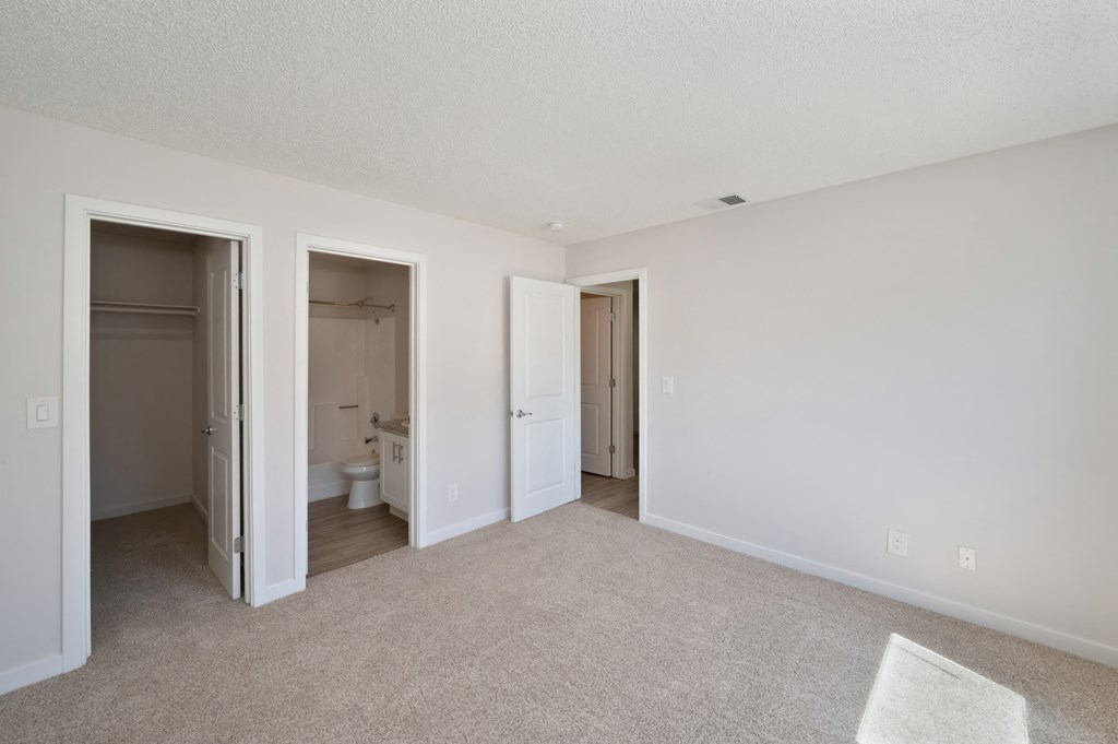 Primary bedroom with large extended closet  and a bathroom attached to room.