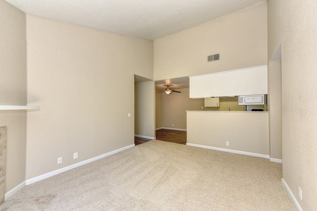 Empty Living room with Carpet, View of Kitchen and Ceiling Fan/Light at Cobblestone Creek Apartments, Roseville, CA