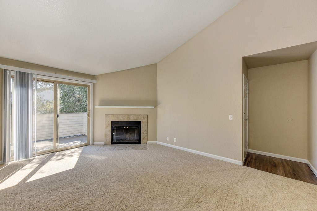 Empty Living Room with Carpet, Large Window and Fire Place at Cobblestone Creek Apartments, California