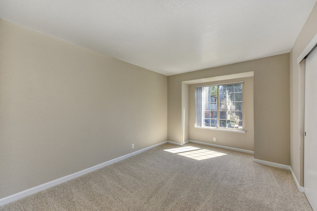 Bedroom with large window and closets along the wall.at Cobblestone Creek Apartments, California, 95661